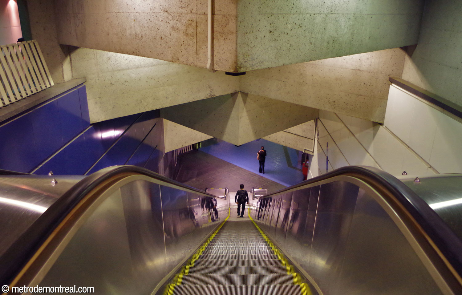 Looking down the main escalator well, with the dramatic 45-degree square coffers above it. The stairwell is clad with enamelled steel panels, dark blue on the left and white on the right.