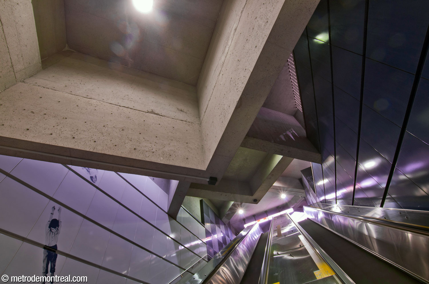 Looking up the main stairwell from the ticket hall to the passage between the headhouses. Above, the square ceiling coffers are set at the usual 45-degree angle relative to the rectangular stairwell. At left, one of the sections of Jean Mercier's mural artwork overlooks the escalators.