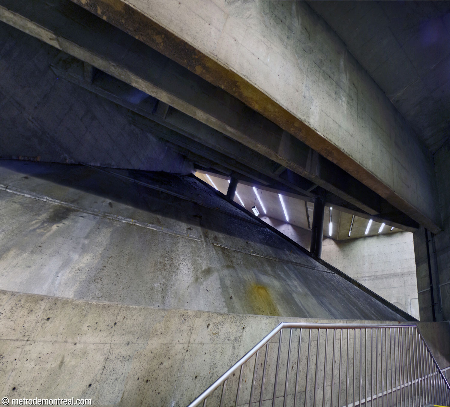 Vue en contre-plongée du vaste espace triangulaire qui relie la tête des escaliers mécaniques au grand volume.