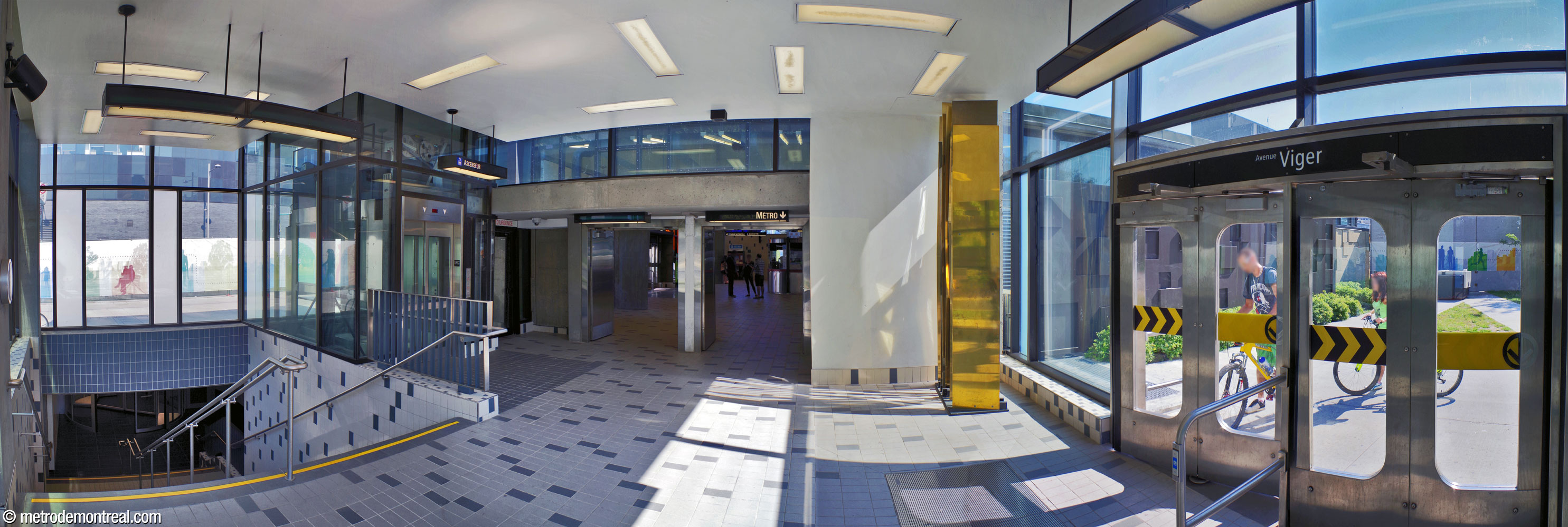 Interior of the addition added to the headhouse in 2014. The doorways in the centre lead to the ticket hall. The underground city link to the CHUM is at left, with an elevator leading to it, and the extension's west-facing entrance is at right. Jacques Bilodeau's sculpture Un solide stands at centre-right.