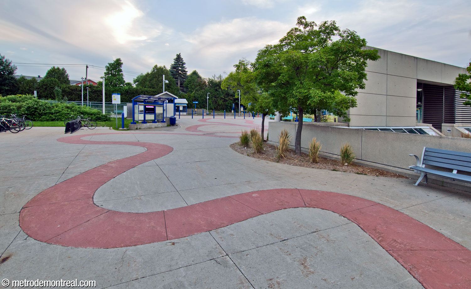 Le tracé de dalles roses continue au niveau du parvis derrière l'édicule, près de la gare.