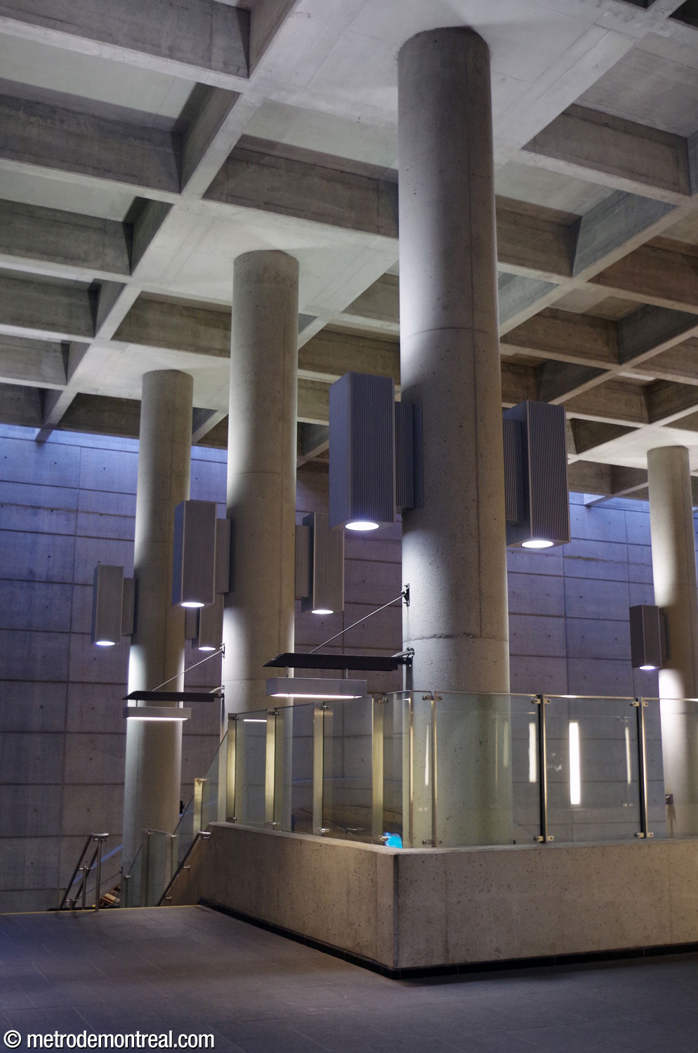 Une rangée de colonnes soutient le plafond à caissons du grand volume et longe la passerelle et l'escalier vers le quai Côte-Vertu.