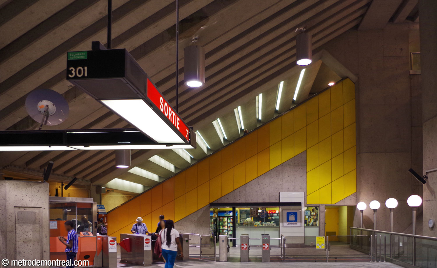 The dramatic slant of the ceiling above the ticket hall matches that of the escalators, which themselves are emphasized by a mural by Gilbert Sauvé in the form of an upward arrow.