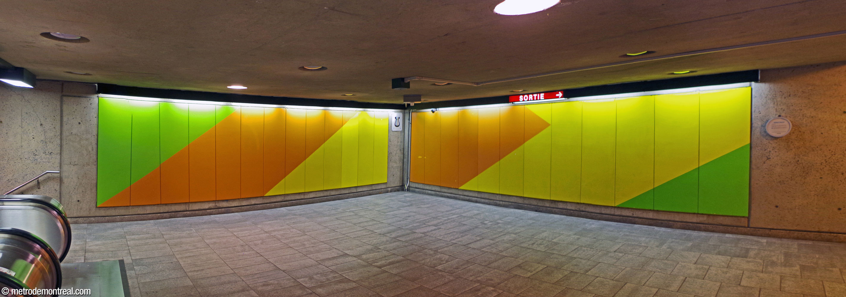 Green, orange, and yellow murals by Gilbert Sauvé point toward the exit from the corner of the walkway at the head of the escalators.