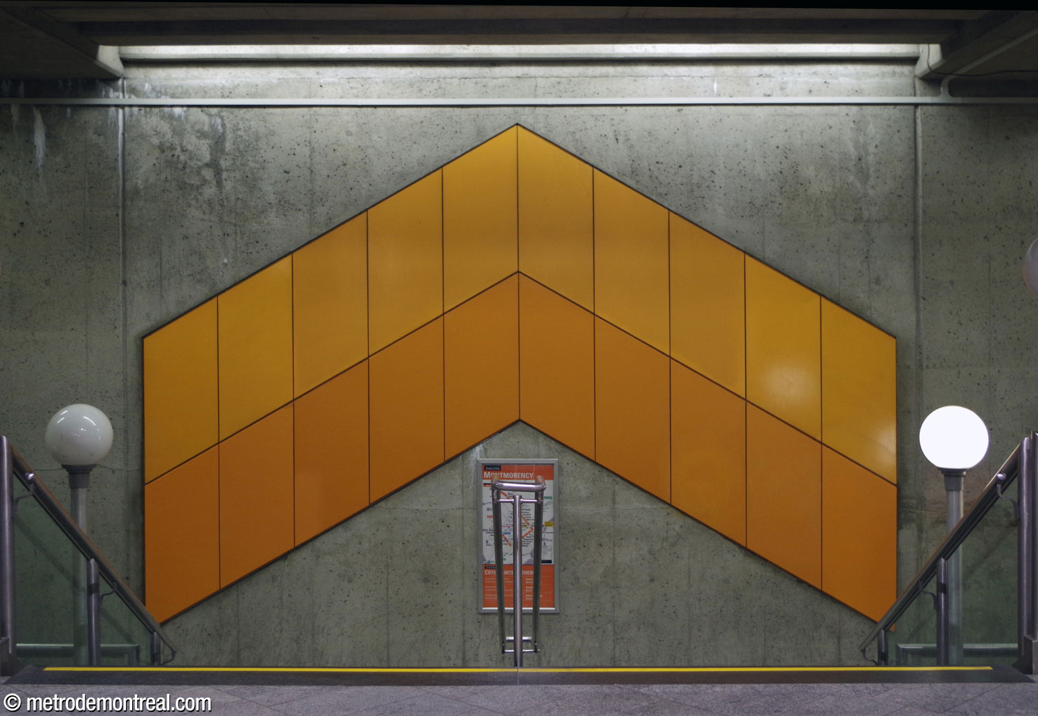 One of the chevron-shaped murals above the stairwells to the platforms, in this case the one to the Montmorency platform, pointing the way upward toward the mezzanine and the exit.