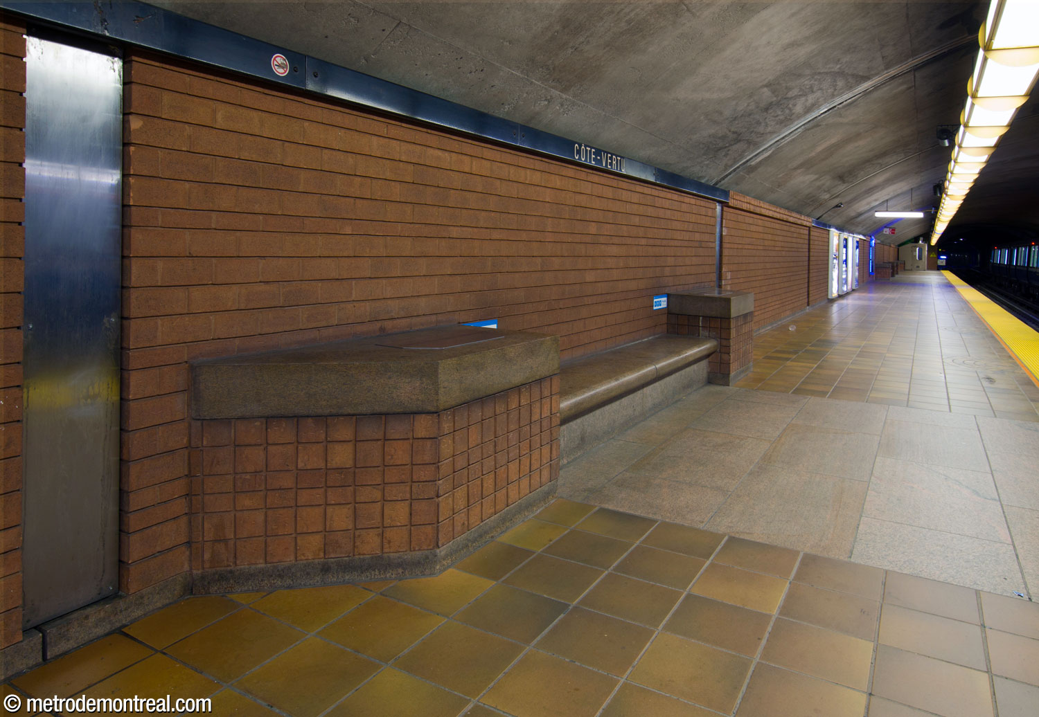 One of the platform benches, with the station's terracotta wall tiles and granite and sandstone floor tiles.
