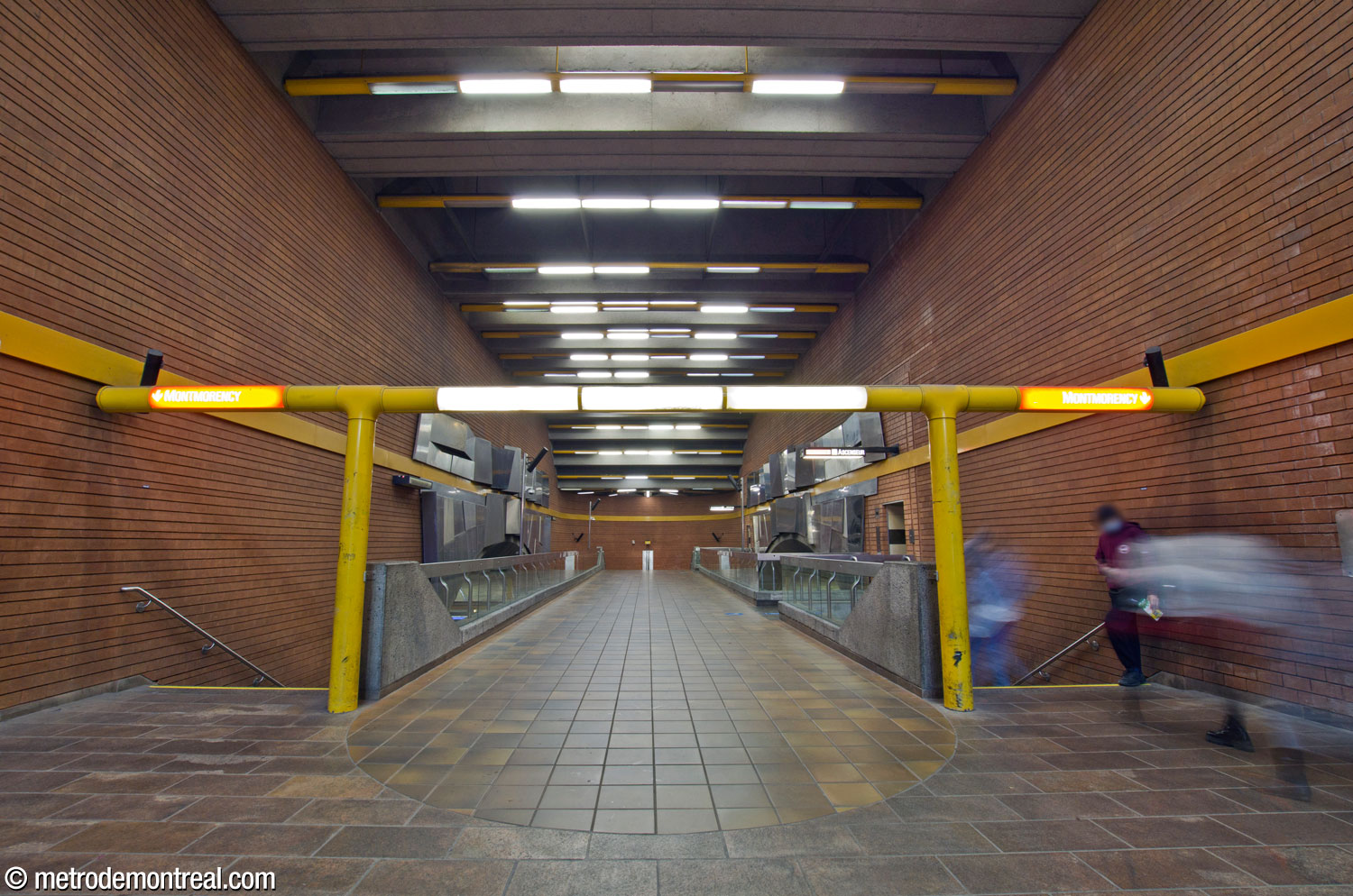 The unique 'gateway' with light fixtures and signage, emphasizing the entrance to the crossover and the platform stairs.