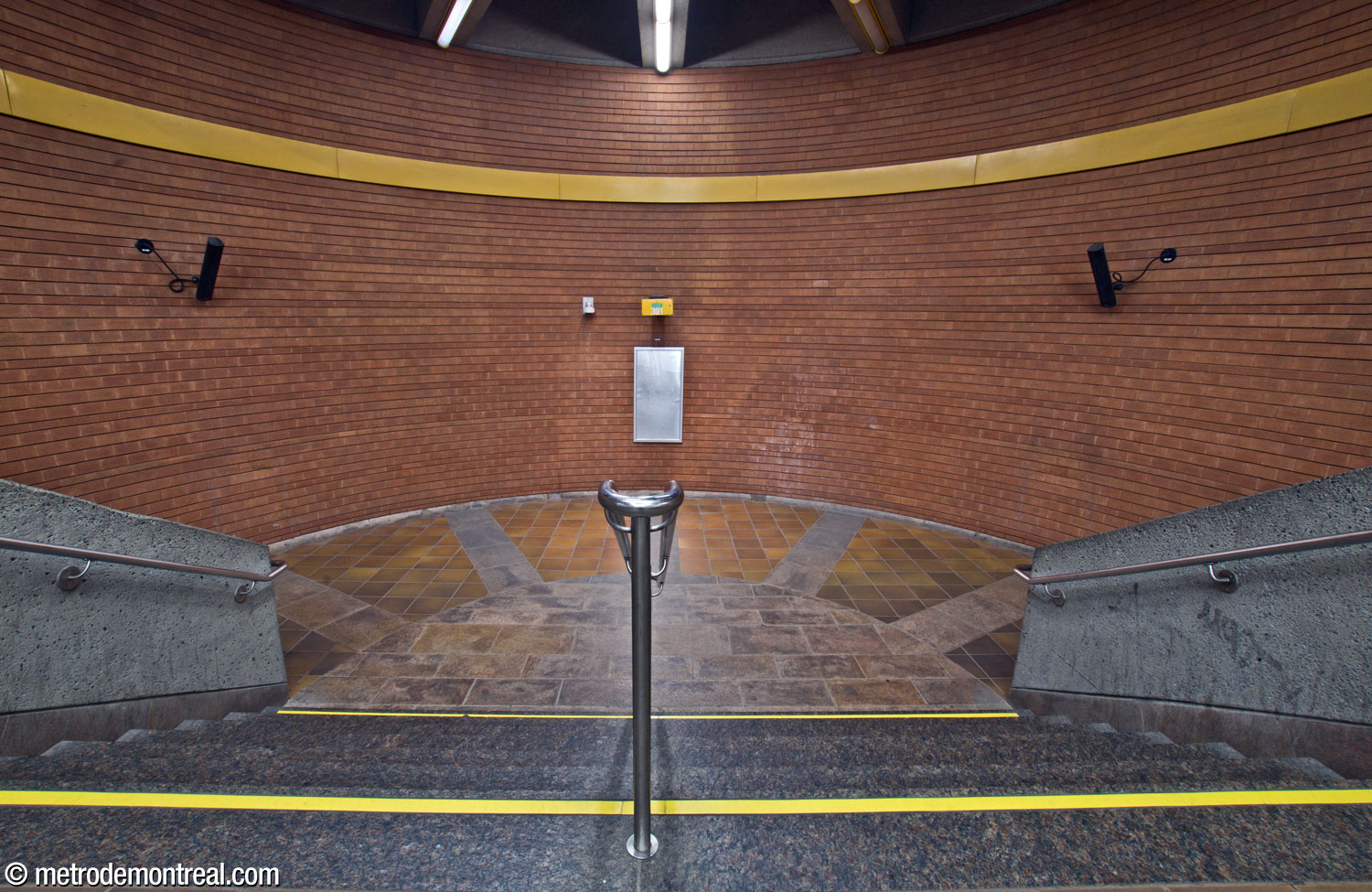 The semicircular landing at the end of the transept, with radial floor tiling emphasizing passengers’ movement through the repeated half-circle plan in the station’s circulation areas.