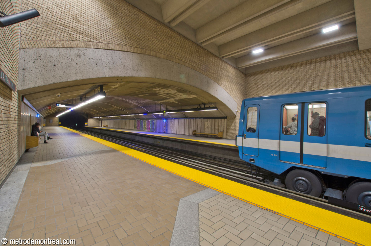 View toward the mined portion of the trainroom east of the main volume. A train at the Saint-Michel platform is just beginning to depart; its position illustrates that the standing positions of the trains on the platforms are offset from each other, each occupying the rear two-thirds of its platform, rather than opposite each other as at all other blue line stations.