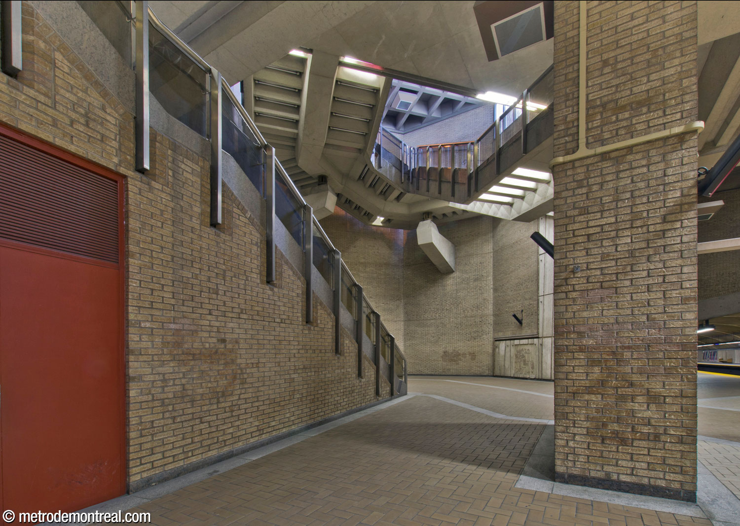 Looking behind a pier on the Saint-Michel platform to the staircase above, which leads from the ticket hall to the Saint-Laurent Ouest headhouse.