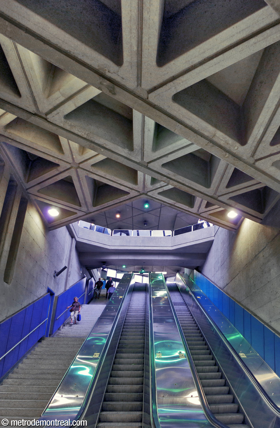 The ceiling above the escalator well in the east access is divided into oblique steps following the angle of the triangular ceiling coffers. The same angle is visible at the ends of the bridge that overlooks the well from the headhouse above.