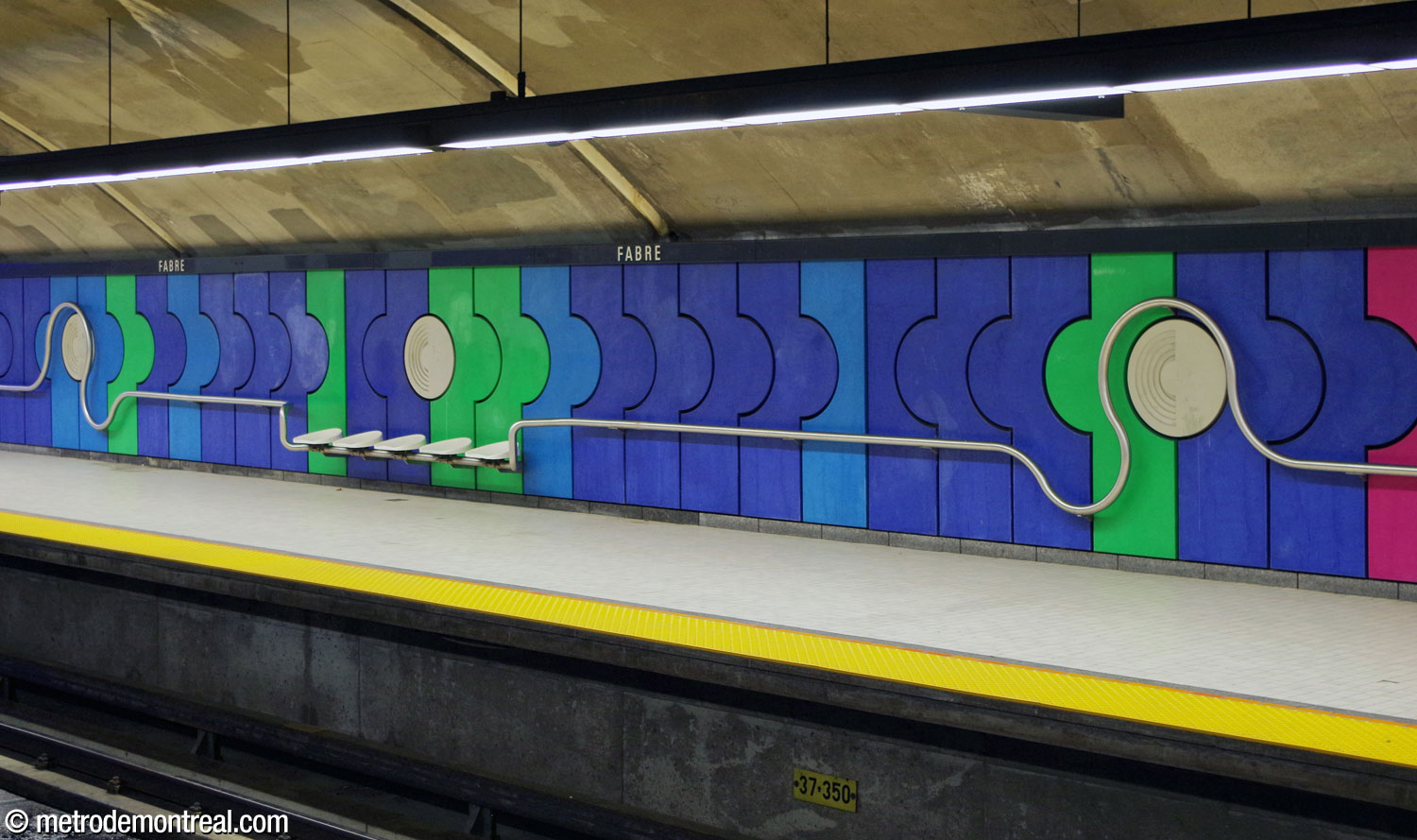 A section of the wall cladding on the Saint-Michel platform, showing the cement panels and the multipurpose steel rail running along the wall.