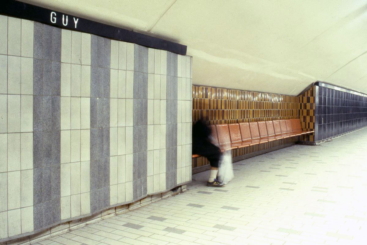 Le carrelage originel bleu, blanc cassé et noir au niveau des quais, avec du carrelage glacé brun et orange au-dessus des bancs.
