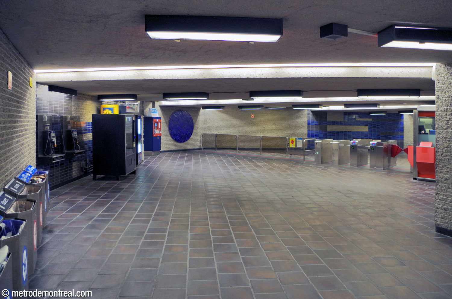 The ticket hall is decorated with blue tiled circles and motifs in dark grey and blue glazed brick similar to those at platform level.