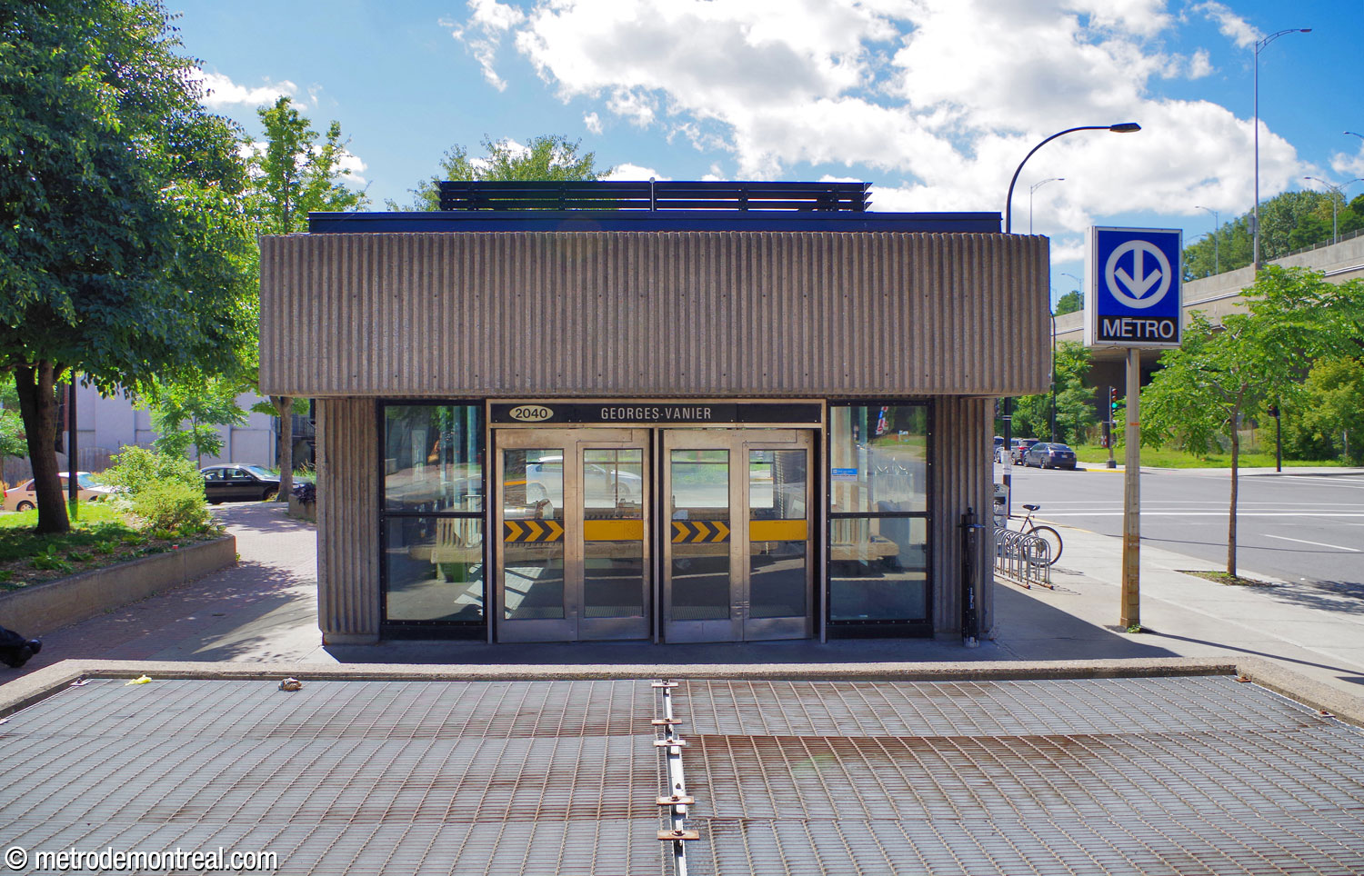The front façade of the station's single headhouse, in glass and vertically grooved concrete.