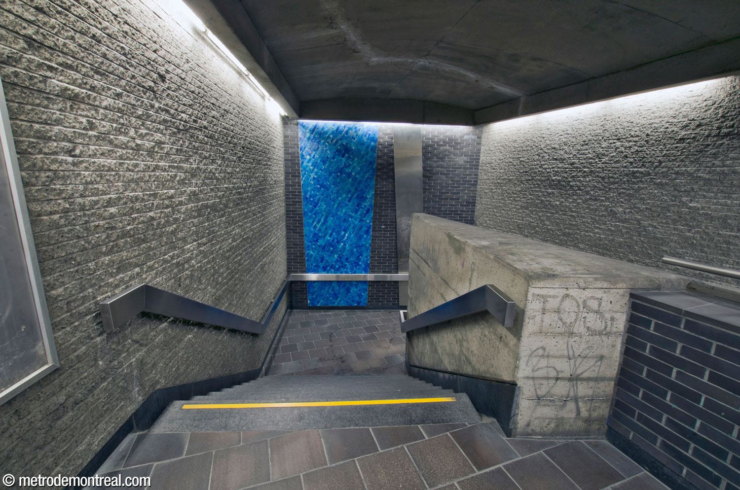 The western staircase to the Montmorency platform at the end of the crossover is enclosed in a stairwell projecting out from the volume. Its oblique, irregular forms are emphasized by a trapezoid of turquoise tiles and a slanting stainless steel panel.