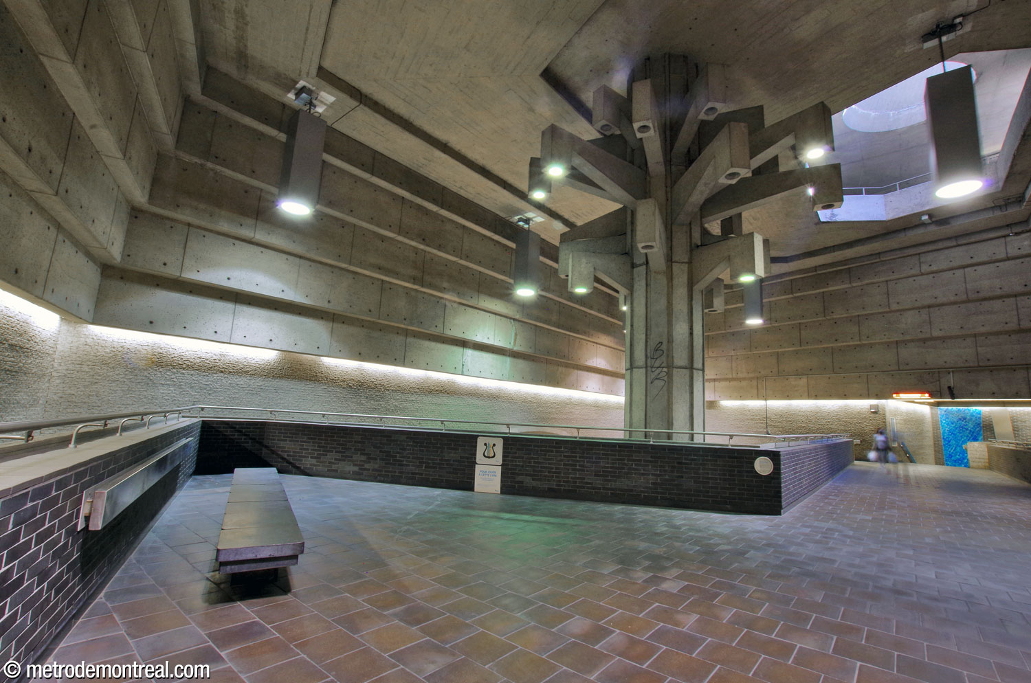 The sculpture Un Arbre dans le parc rises above the triangular waiting area at the north end of the crossover.