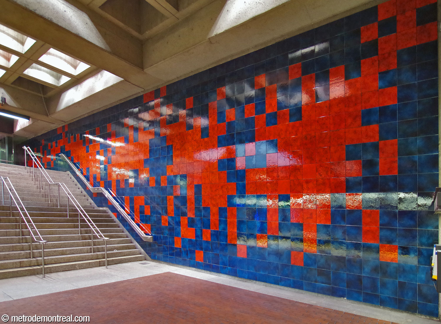 Ceramic mural by Jean-Paul Mousseau, with red forms on a blue ground, over the staircase from the arrival platform.
