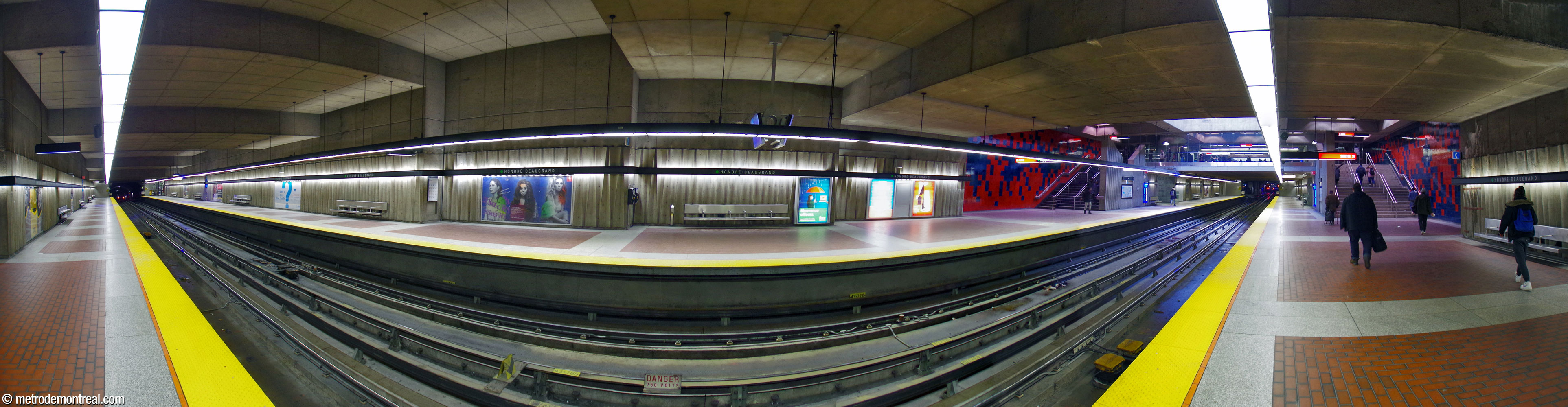 Panorama of the trainroom, showing the stepped ceiling of the cut-and-cover volume. The stairs to the ticket hall, at right, are highlighted by murals by Jean-Paul Mousseau.