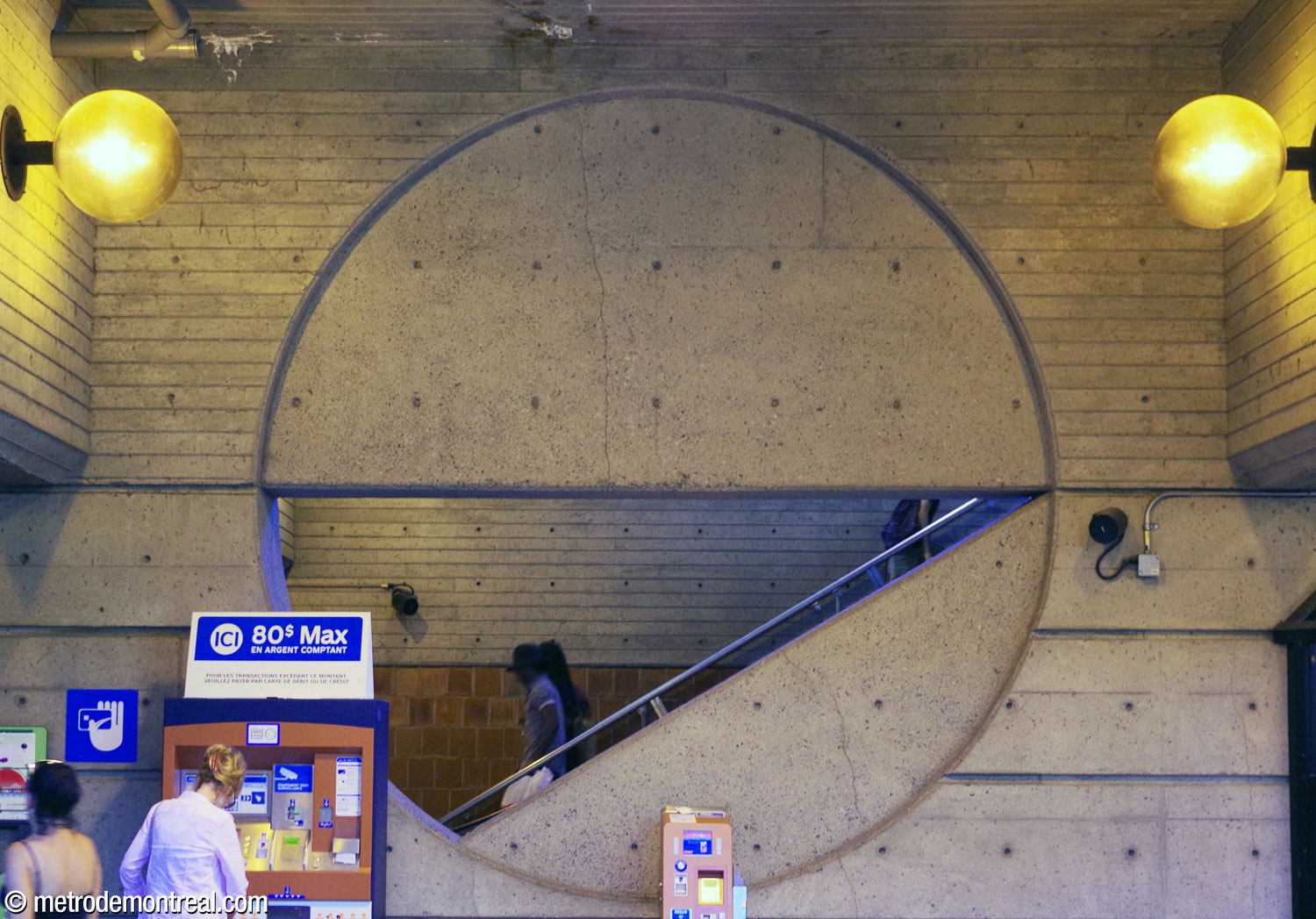 A large circular form on the wall dividing the upward stairwell from the ticket hall. The circle's diameter and the diagonal line of the staircase form an opening to admit still more natural light.