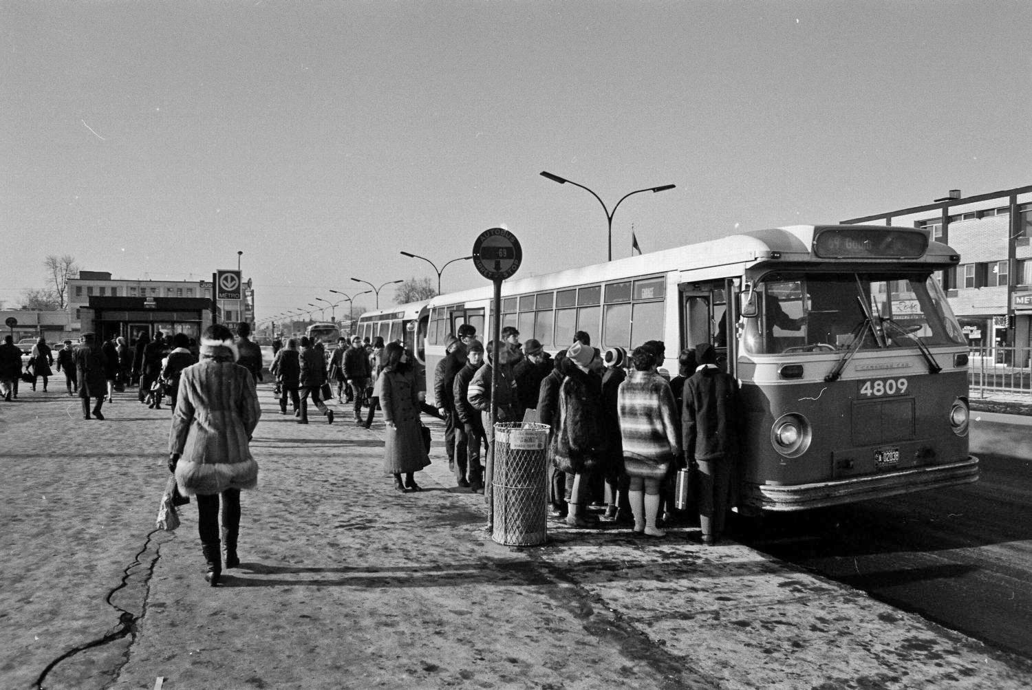 Passengers board a bus on Boulevard Henri-Bourassa alongside the north bus terminal entrance.