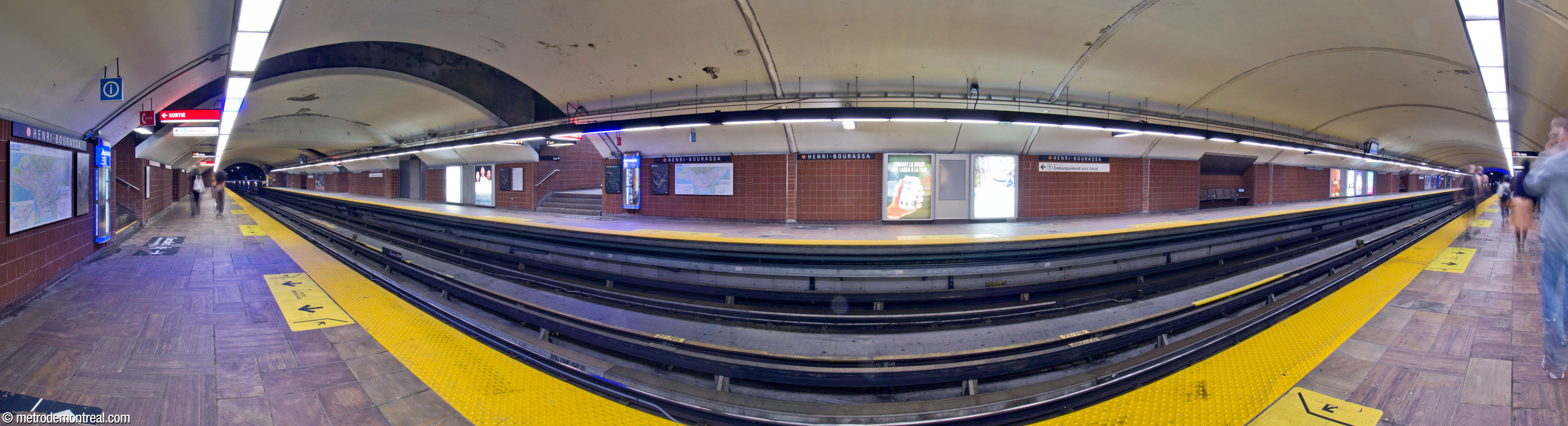Panorama of the original trainroom from the Côte-Vertu platform. The trainroom vault, built in tunnel, is intersected (left) by the enclosed crossover and, on either side of it, the rectangular hallways to the stairwells, each pair forming a box intersecting the vault.