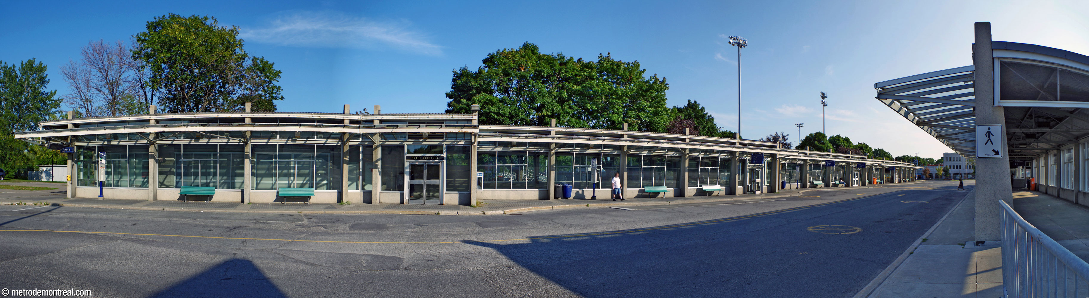 Overview of the lengthy south building of the Henri-Bourassa Sud bus terminal. The glass, concrete, and steel building extends along the south side of the bus loop. The north building is at right.