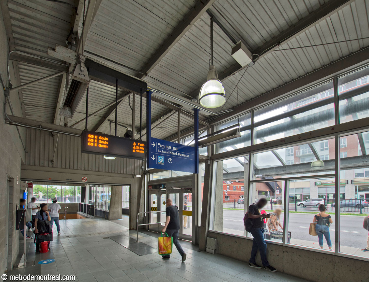 Interior of the north building of the bus terminal. The stairs and elevator to the ticket hall level are at the far end. An entrance is located on the north side facing the street (centre), with the entrance from the bus loop located behind the viewer.