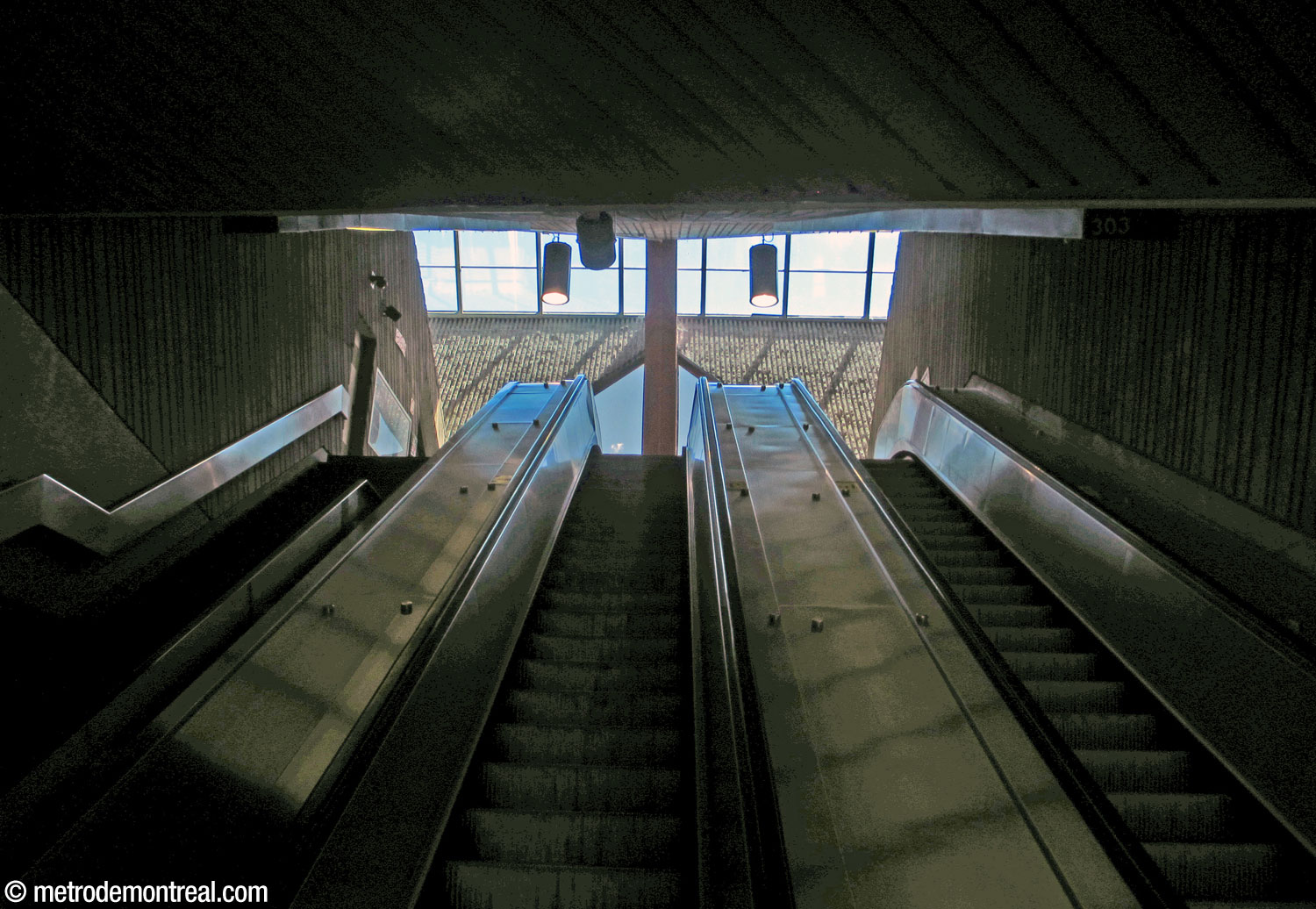 Les escaliers mécaniques entre la mezzanine et le rez-de-chaussée. On voit également la claire-voie de l'édicule.