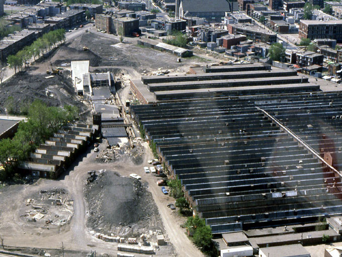 Vue aérienne des alentours durant la construction de la station; on voit les anciennes usines de munitions à droite et en arrière de la station.