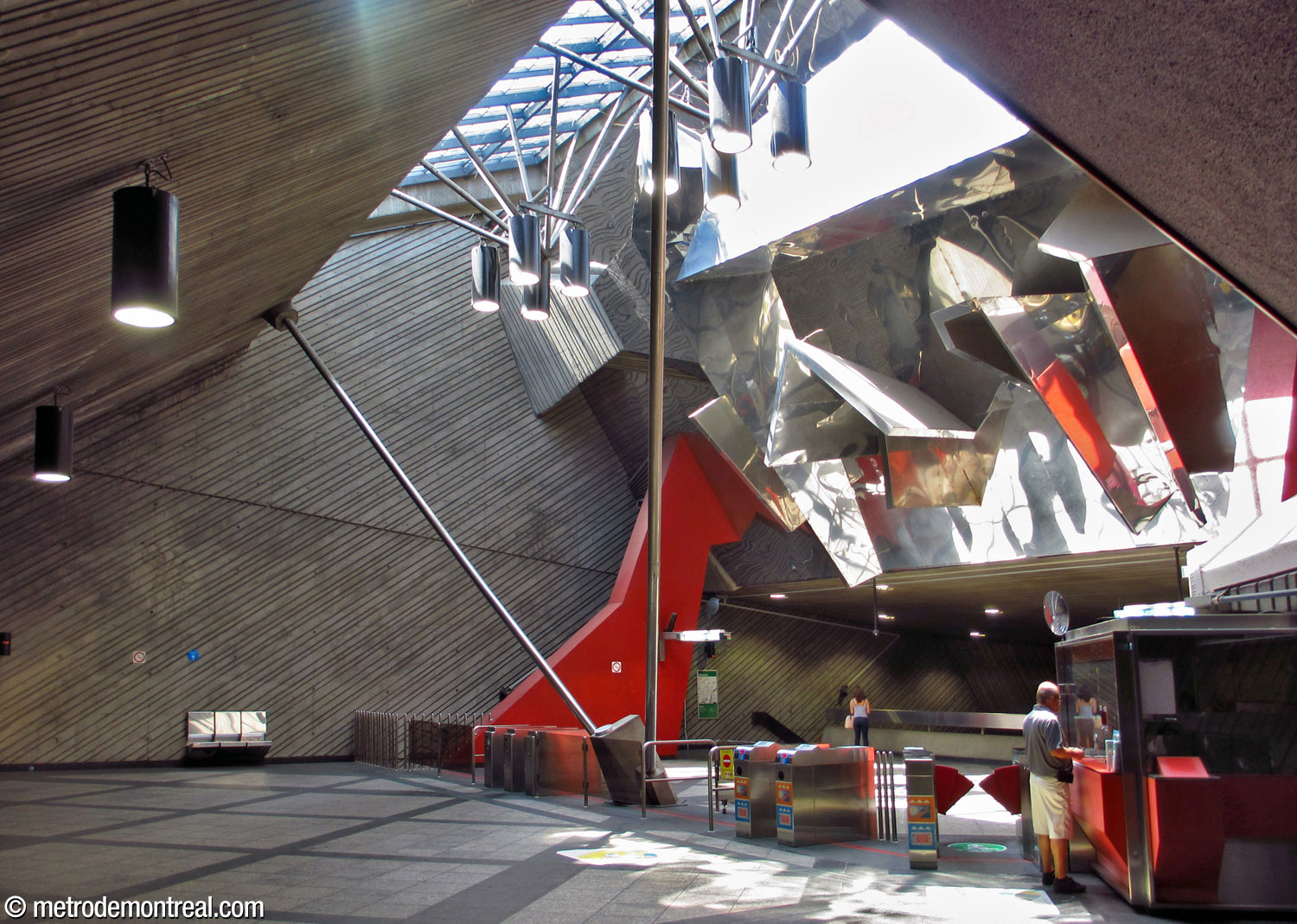 Vue de la mezzanine qui accueille la billetterie. Au-dessus, un puits de lumière illumine une sculpture murale de Peter Gnass, qui reflète le soleil dans tout l’espace. La mezzanine est partiellement suspendue des deux longues tiges de métal qui la relient au toit.