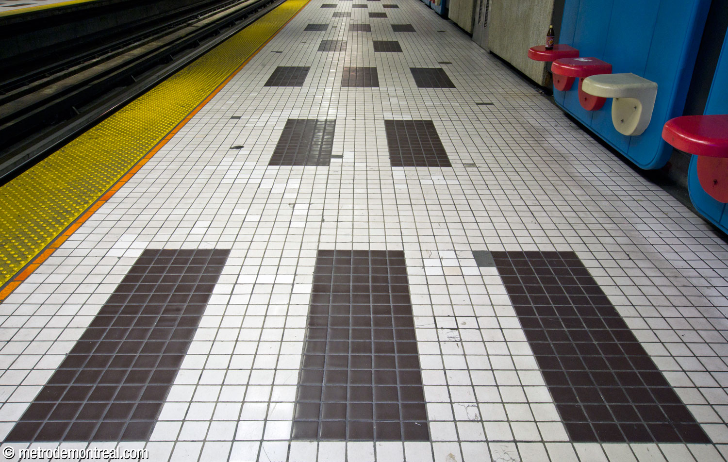 Un motif de rectangles en alternance fait de carreaux noirs et blancs au niveau des quais.
