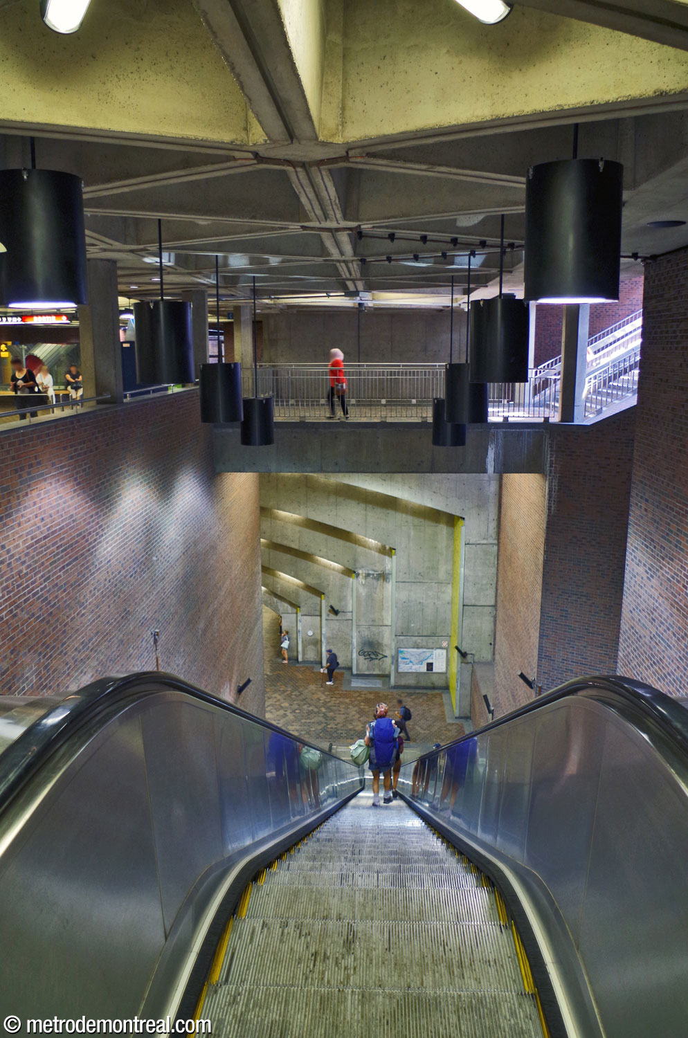 The stairwell leading from the ticket hall to the Montmorency platform, seen from the top of the stairs. Overhead, a bridge connects the concourse with the stairs to the main headhouse.