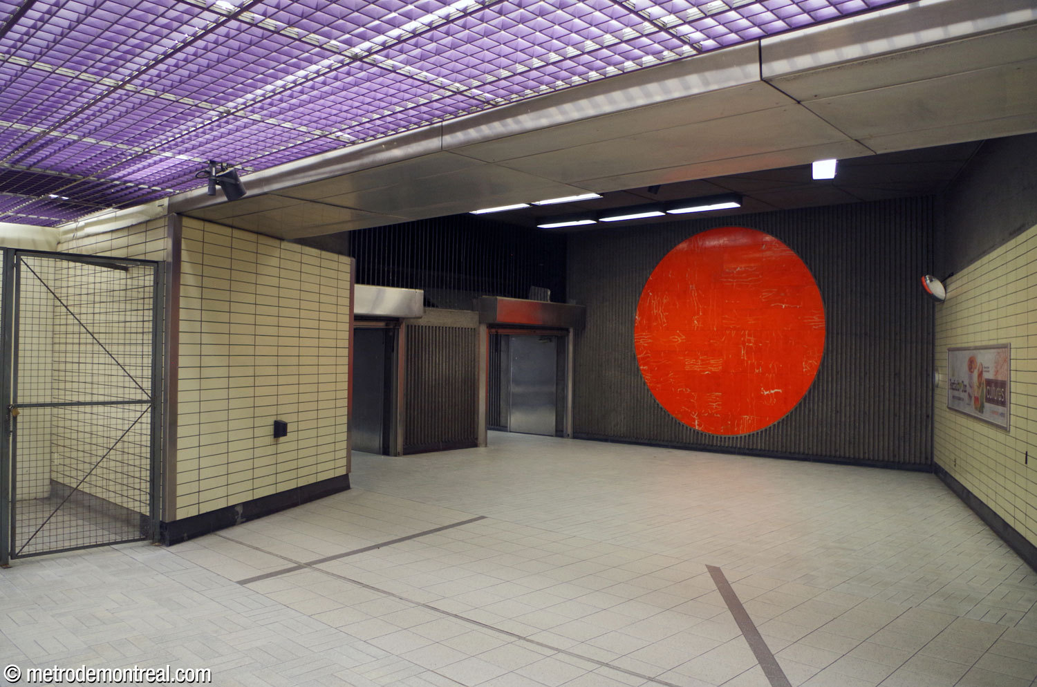 Le pied des escaliers reliant la salle de contrôle à l'accès Berri Est. La grande murale circulaire Horizons, œuvre de Mario Merola fait en porphyre orange, occupe le mur adjacent.