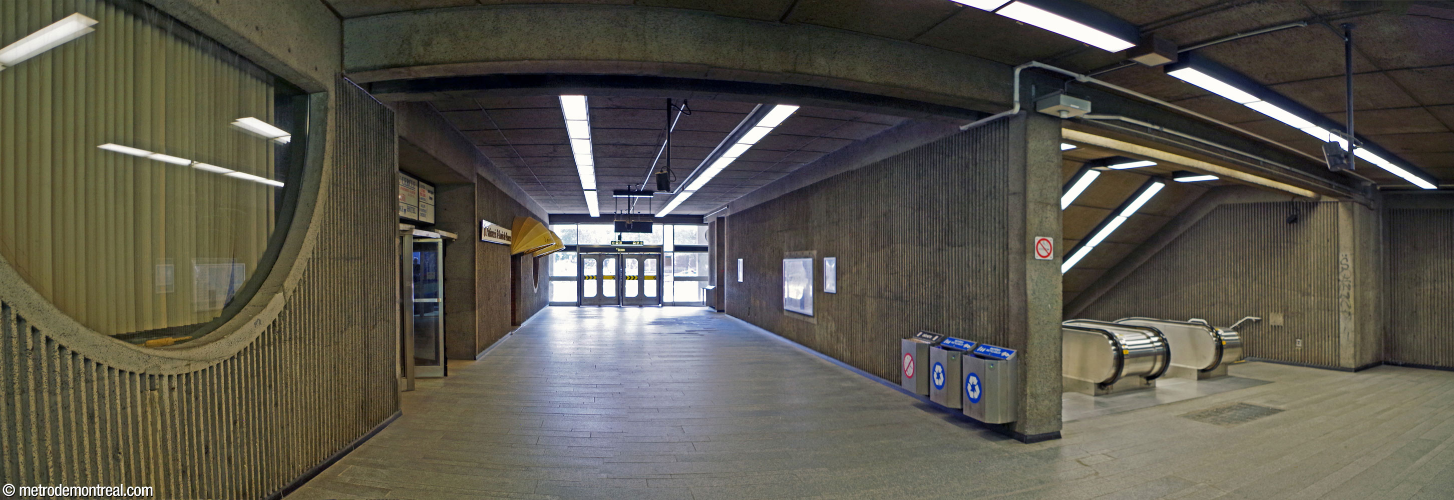 L'intérieur de l'accès Berri Est. Son style brutaliste, typique de l'époque de sa construction en 1972, détonne quelque peu avec le restant de la station et du réseau initial. La sortie se trouve au fond; l'escalier vers la station est à droite. À gauche, un couloir menant à des commerces situés aux rez-de-chaussée de l'immeuble.