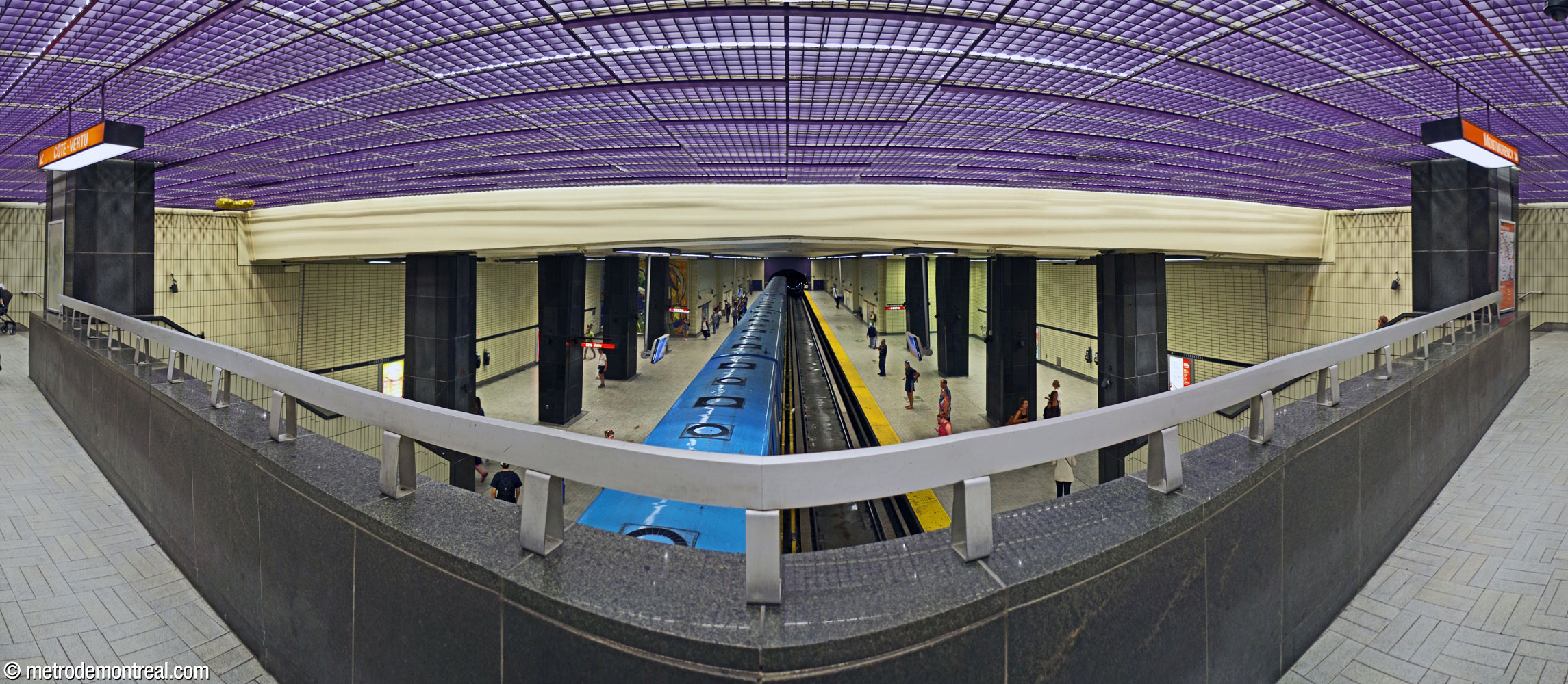 Regard vers le nord à partir du parapet où la zone contrôlée de la mezzanine donne sur les quais. De part et d'autre, on voit les larges escaliers vers les quais et les collatéraux sur lesquels ils débouchent.