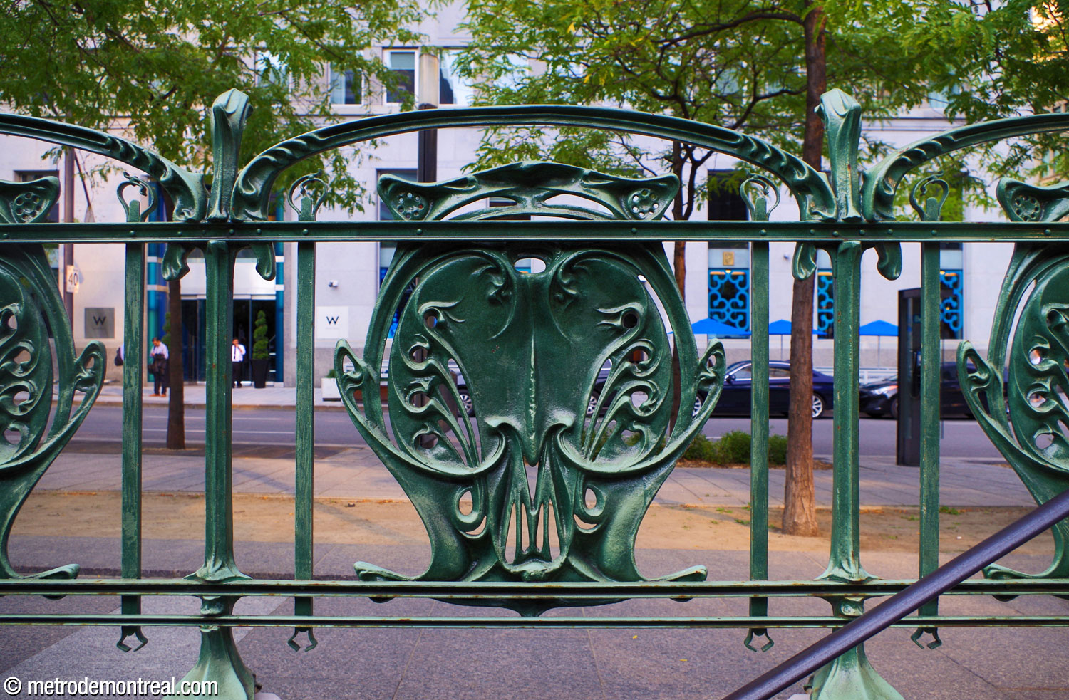 L'un des flamboyants écussons du grillage de l'entourage Guimard. La profusion de détail décoratif constitué de formes biomorphiques fluides et élégantes est typique du mouvement Art nouveau de la fin du XIXe et le début du XXe siècle, mouvement dont Guimard fut l'un des principaux exposants.