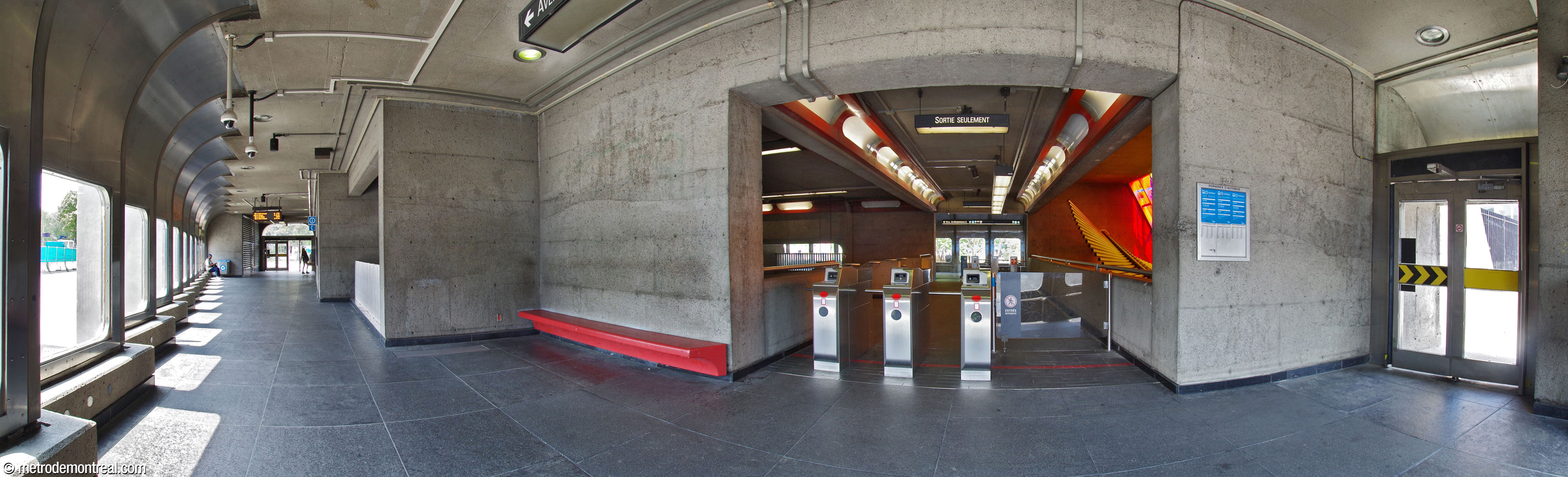 Le déambulatoire sud dans le premier édicule. On fait face à la passerelle entre les deux déambulatoires. Depuis la première phase des rénovations en lien avec la construction du CUSM, aucun escalier ne permet de descendre de ce déambulatoire directement à la salle de contrôle, à différence de son homologue du côté nord. Il servait uniquement de sortie et d’aire d’attente jusqu’à ce qu’on ait remplacé les tourniquets vers la passerelle en 2025, afin de restaurer l’accès vers la station à partir de ce côté.