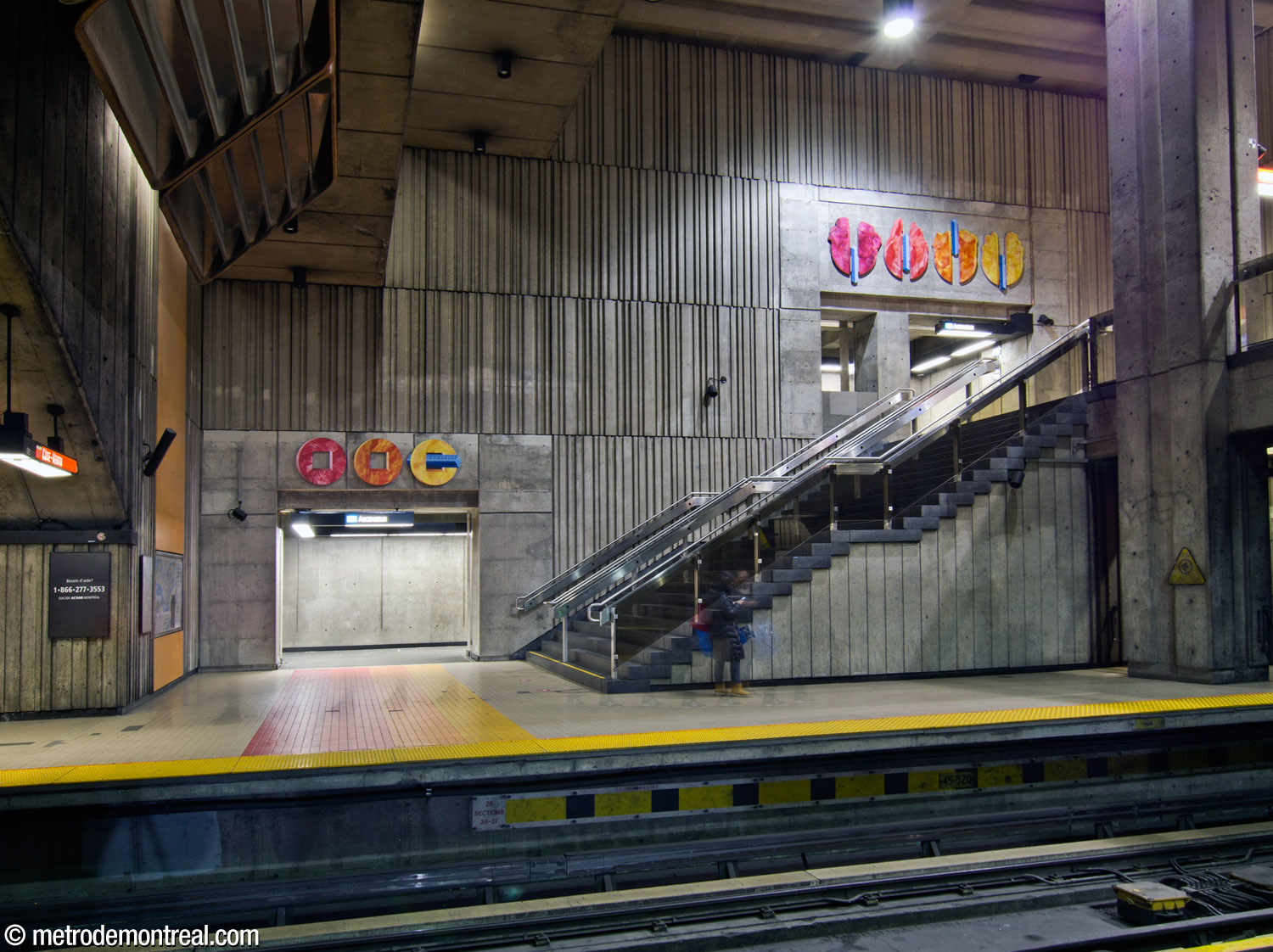 The east wall of the main volume at the south end of the Côte-Vertu platform. Two sections of Marianne Chevalier's artwork La correspondance des strates are located over the openings leading to the elevator serving that platform.